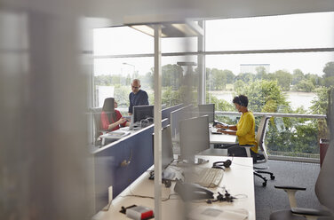 Woman with headset working in open-plan office - RHF000945