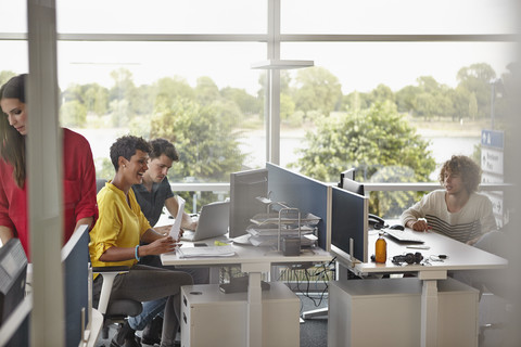 Kollegen arbeiten in einem Großraumbüro, lizenzfreies Stockfoto