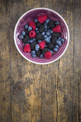 Bowl of different wild berries on wood - LVF003685