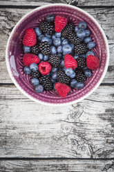 Bowl of different wild berries on wood - LVF003684