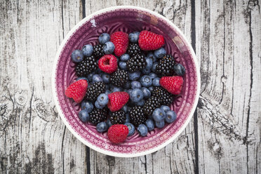 Bowl of different wild berries on wood - LVF003683