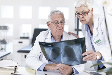 Zwei Ärzte am Schreibtisch besprechen ein Röntgenbild - ZEF006000