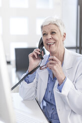 Smiling senior woman in lab coat on the phone - ZEF006058