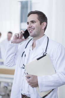 Smiling doctor in hospital on the phone - ZEF006083