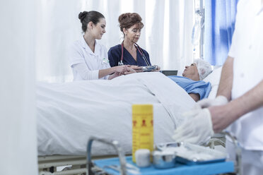 Doctors in hospital at patient's bed - ZEF006502
