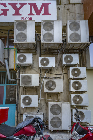 VAE, Dubai, mehrere Klimageräte an einer Wand in einer Seitenstraße, lizenzfreies Stockfoto