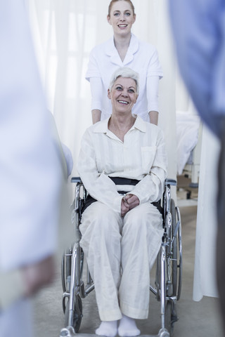 Krankenschwester mit älterer Patientin im Rollstuhl, lizenzfreies Stockfoto