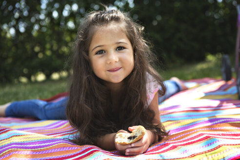 Portrait of smiling little girl lying on a blanket - GDF000819