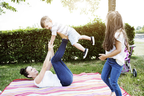 Woman balancing her little son on her feet stock photo