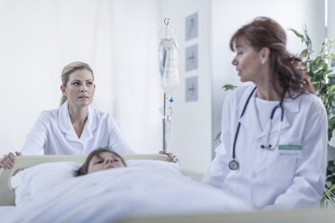 Arzt und Krankenschwester schieben Krankenhausbett mit Patient - ZEF006803