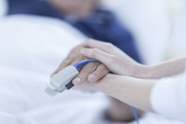 Finger-Herzmonitor am Patienten, Krankenschwester hält Hände - ZEF006545