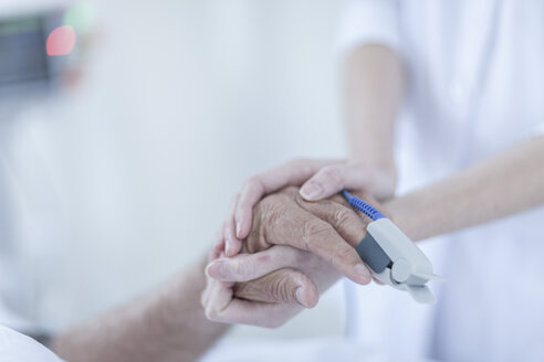 Finger-Herzmonitor am Patienten, Krankenschwester hält Hände - ZEF006546
