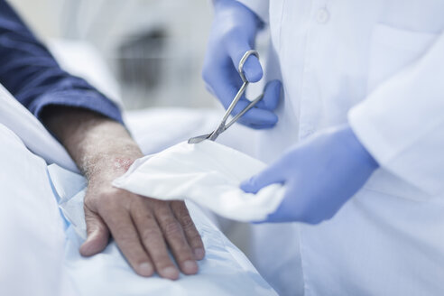 Krankenschwester säubert die Hand des Patienten vom IV-Tropf - ZEF006549