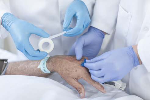 Krankenschwester führt IV-Nadel in die Hand des Patienten ein - ZEF006553