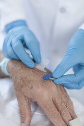 Krankenschwester führt IV-Nadel in die Hand des Patienten ein - ZEF006554