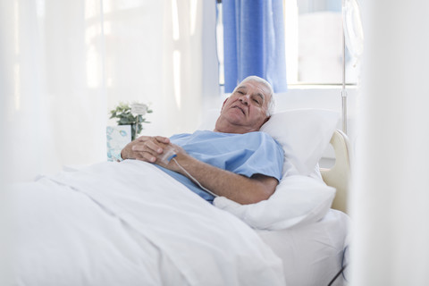 Älterer Patient im Krankenhausbett liegend, lizenzfreies Stockfoto