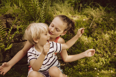 Mädchen und kleiner Junge spielen im Garten - MFF001889