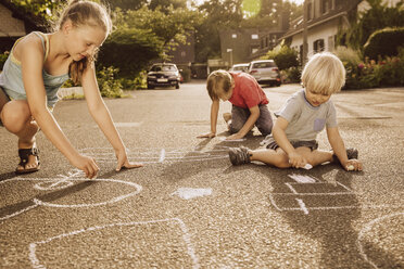 Children using sidewalk chalk in their neighborhood - MFF001946