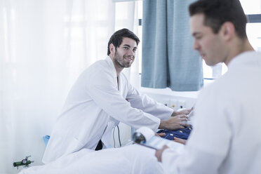 Two doctors examining a patient in a hospital room - ZEF006259