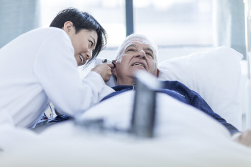 Doctor examining patient with otoscope in a hospital - ZEF006263