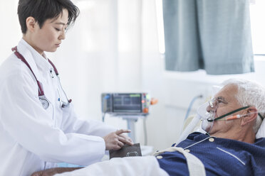 Arzt misst den Blutdruck eines älteren Mannes mit Sauerstoffmaske in einem Krankenhaus - ZEF006266