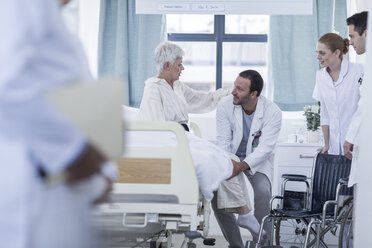 Doctor and staff helping patient with wheelchair in hospital - ZEF006855