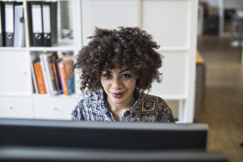 Junge Frau im Büro bei der Arbeit am Computer - FKF001205