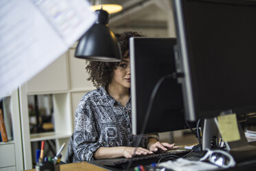 Junge Frau im Büro bei der Arbeit am Computer - FKF001207