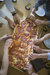 Kollegen im Büro teilen sich eine Pizza - FKF001219