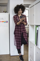 Junge Frau im Büro mit digitalem Tablet - FKF001226