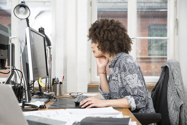 Junge Frau im Büro bei der Arbeit am Computer - FKF001246