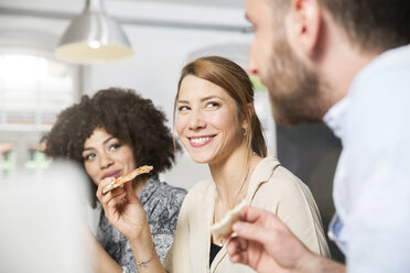 Drei Kollegen im Büro beim Pizzaessen - FKF001278