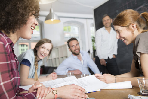 Glückliche Kollegen im Büro bei einer Besprechung - FKF001283