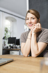 Portrait of smiling young woman in office - FKF001300