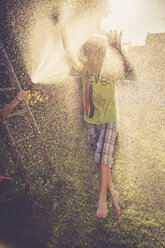 Boy and girl having fun with splashing water in the garden - SARF002061