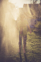 Boy splashing with water in the garden - SARF002034