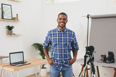 Portrait of smiling young man in his photographic studio - EBSF000769