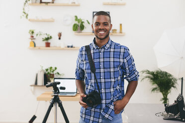 Portrait of smiling young man in his photographic studio - EBSF000771