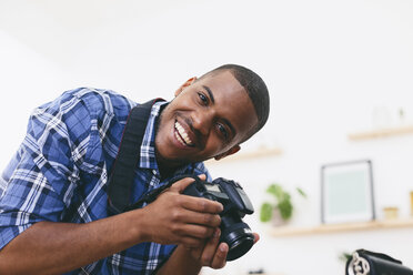 Portrait of smiling young man in his photographic studio - EBSF000773