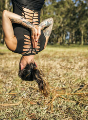 Spanien, Villaviciosa, Frau übt Luft-Yoga im Freien - MGOF000331