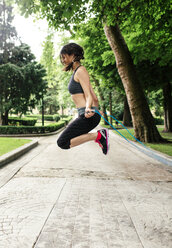 Spain, Oviedo, young woman jumping rope in the park - MGOF000318