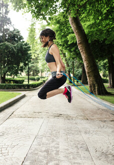 Spanien, Oviedo, junge Frau beim Seilspringen im Park - MGOF000318