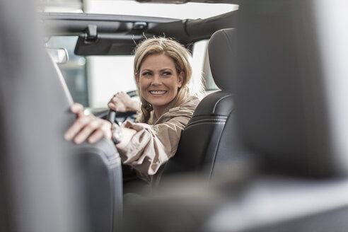 Lächelnde Frau im Auto auf der Rückfahrt - ZEF006917