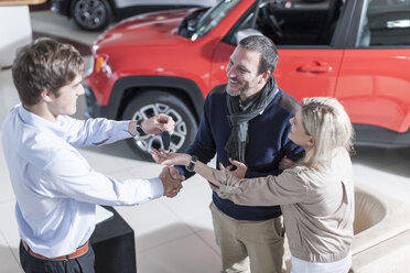 Car dealer giving key to client - ZEF006924