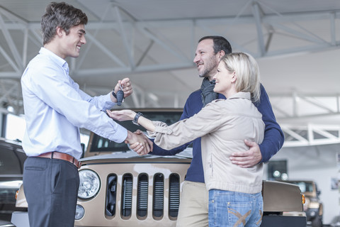 Autohändler übergibt Schlüssel an Kunden, lizenzfreies Stockfoto