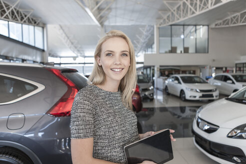 Lächelnde junge Frau im Autohaus - ZEF006931