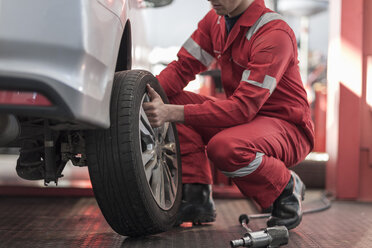 Car mechanic at work in repair garage, changing tires - ZEF006993