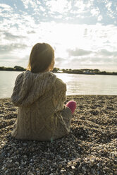 Young woman sitting by the riverside - UUF004988