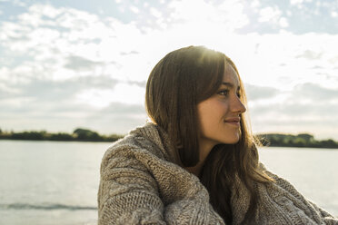 Smiling young woman by the riverside - UUF004990