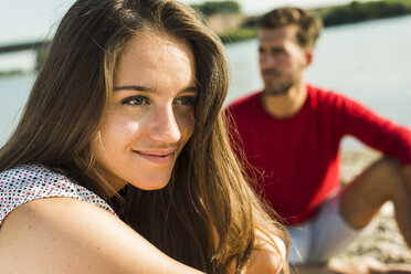 Lächelnde junge Frau und Mann am Flussufer - UUF005015